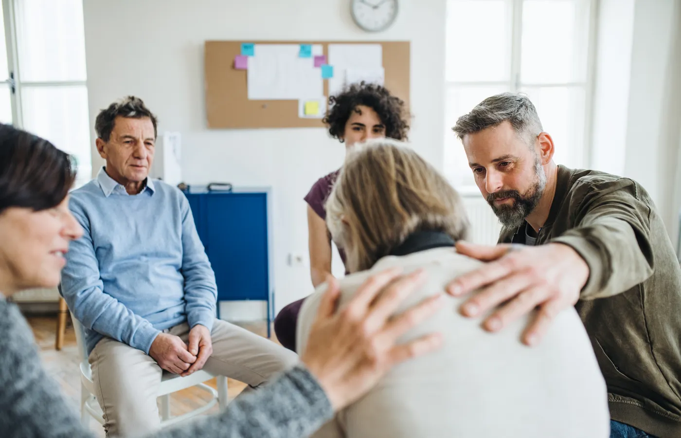 A group therapy session, with one member comforting another
